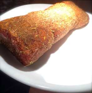 Spice rubbed BBQ pork roast ready to sear in a hot pot.