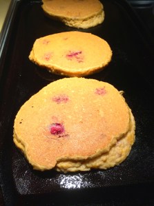 Raspberry pancakes on the griddle.